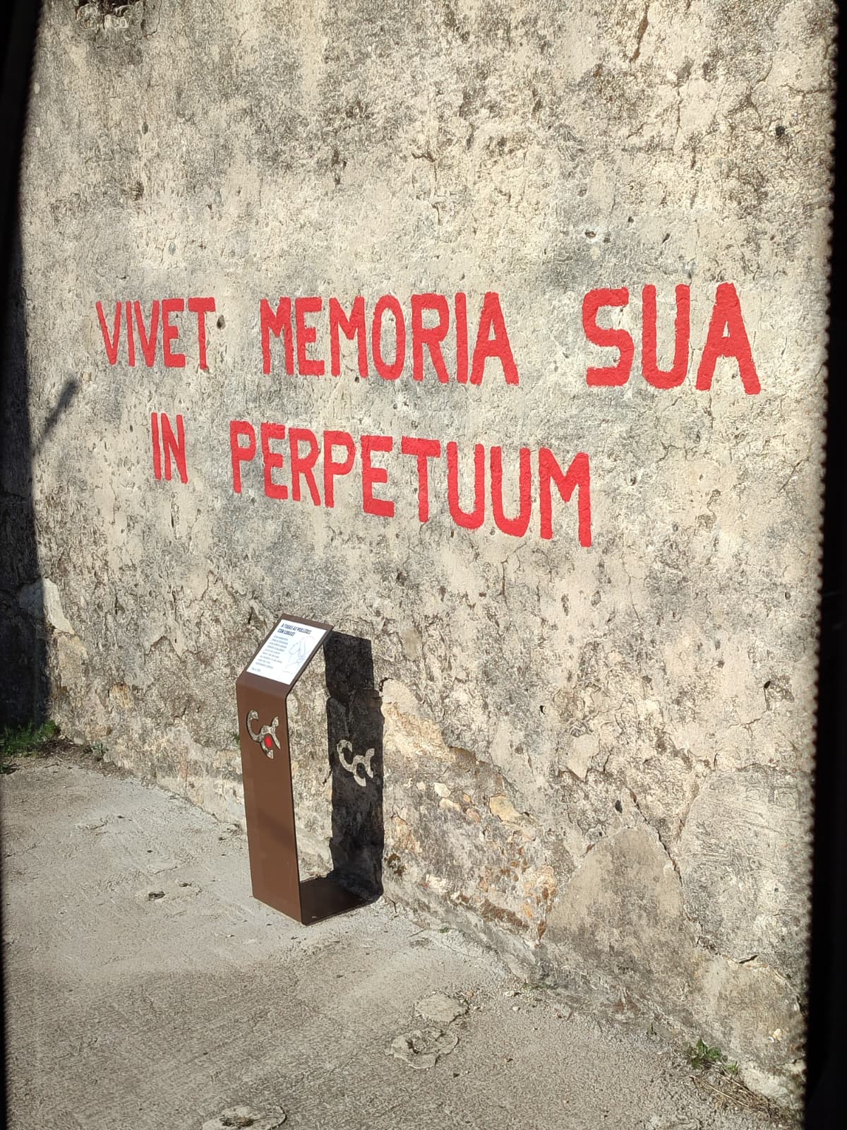 Inscripción «Vivet memoria sua in perpetuum» en un muro del colegio de Camposancos.