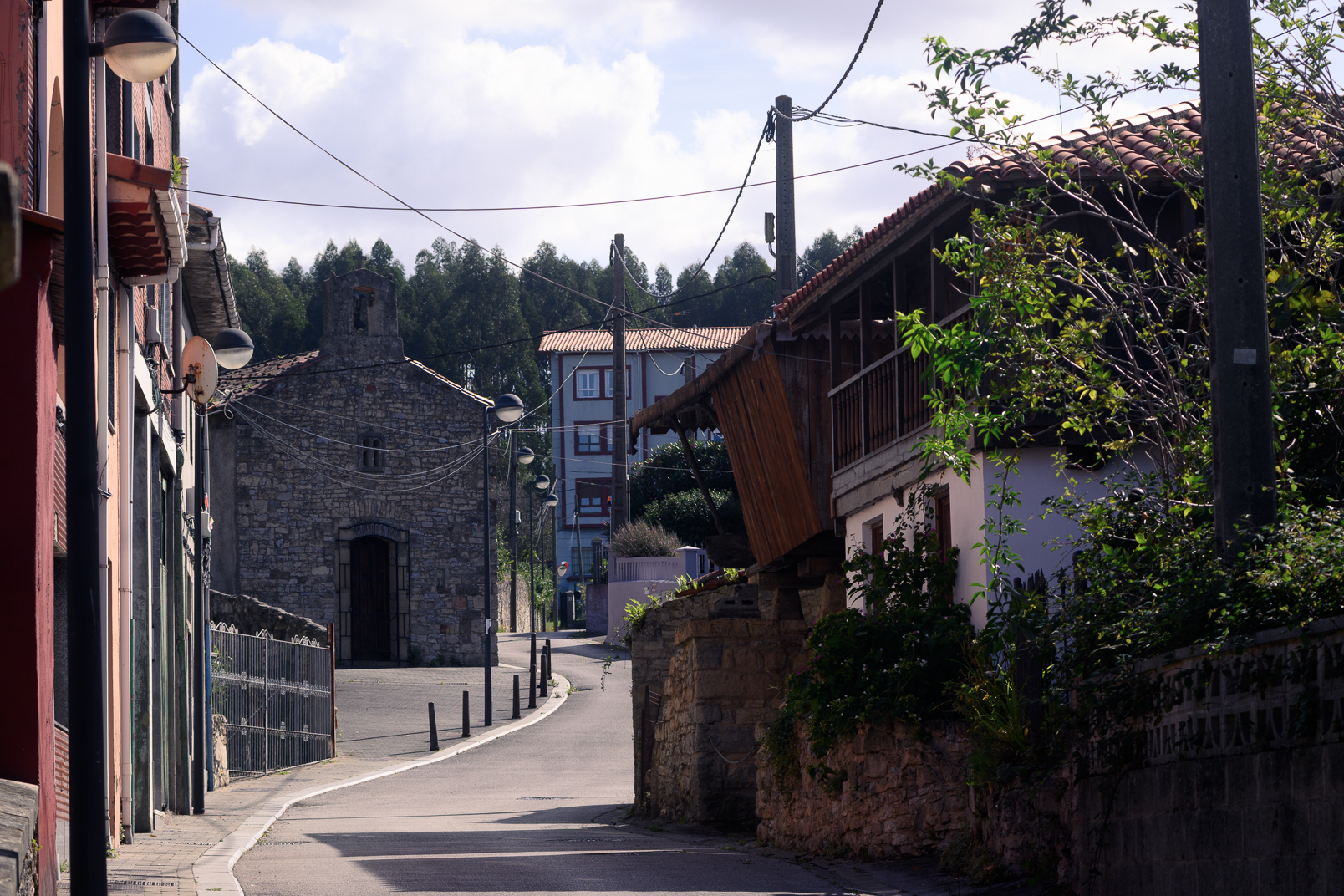 Calle de Llaranes Viejo con una capilla de piedra y construcciones tradicionales.