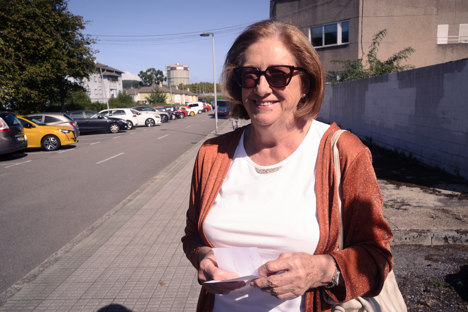 Maribel Morán, con gafas de sol y chaqueta rojiza, en una calle de Llaranes.