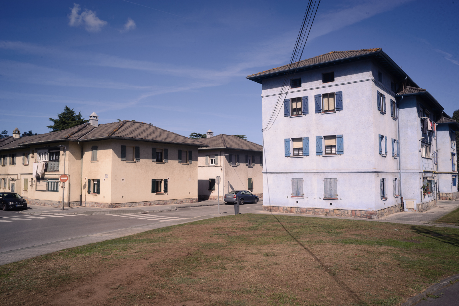 Bloques bajos de viviendas de Llaranes, con contraventanas azules y espacios verdes.